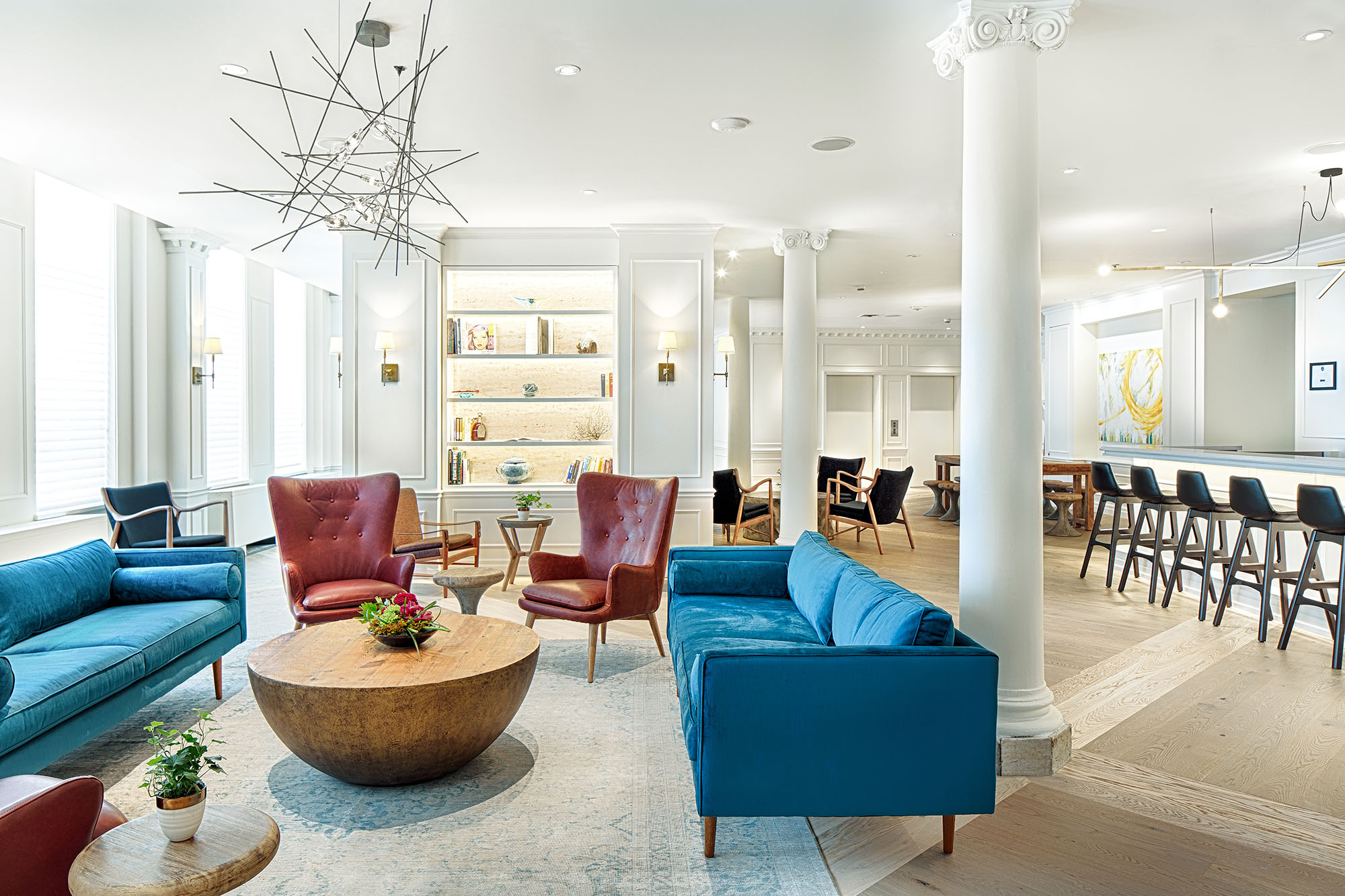 lounge area with blue couches and maroon chairs