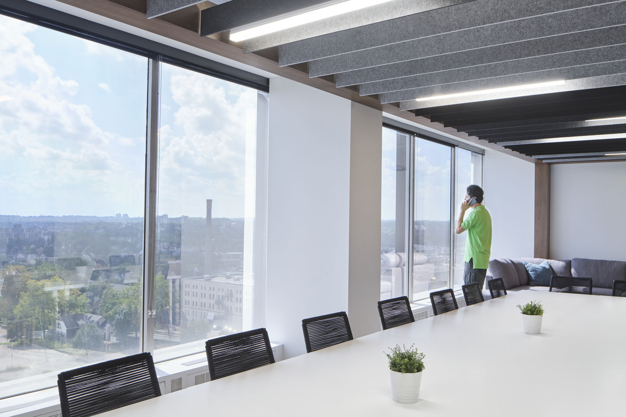 upper level boardroom with big windows and man on phone looking at the view